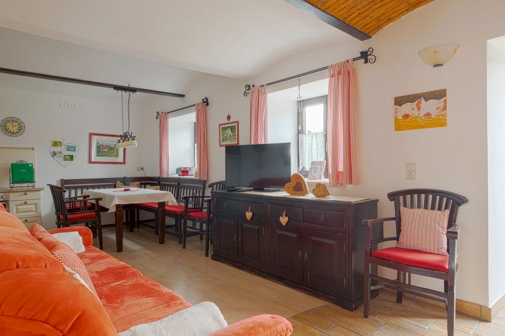 Raum von der Schweinchenwohnung mit Esszimmer Kommode, Couch, Sessel und Fernseher